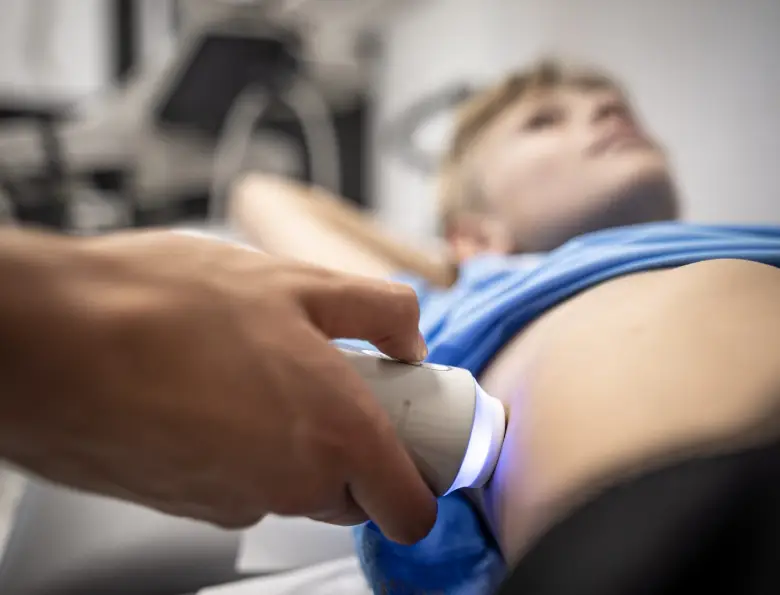 Badanie elastograficzne wątroby FibroScan – sonda przyłożona w prawym międzyżebrzu pacjenta leżącego z uniesionym ramieniem